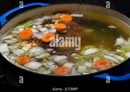 Gemüse-Schinken-Suppe Kochen auf dem Herd mit Karotten Zwiebeln Stockfoto