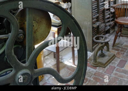 Antike Print Shop Interieur mit Druckmaschine Schwungrad. Stockfoto