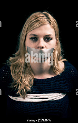 Frau als Geisel mit Klebeband den Mund entführt und mit Seilen gefesselt Stockfoto