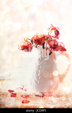 Rosa Rosen in Vase über glänzenden Hintergrund getrocknet Stockfoto