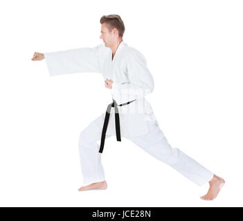 Junger Mann im Kimono üben Karate Over White Background Stockfoto