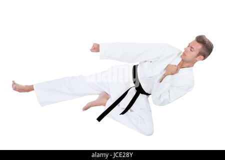 Junger Mann im Kimono üben Karate Over White Background Stockfoto