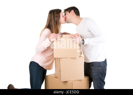 Glückliches Paar küssen über Boxen im neuen Haus Wohnung Stockfoto