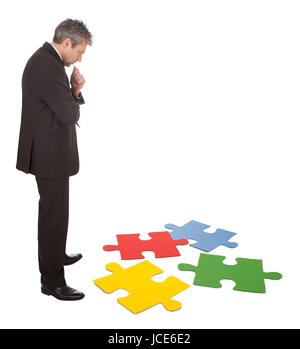 Leitenden Geschäftsmann Montage eine Puzzle. Isoliert in weiss Stockfoto