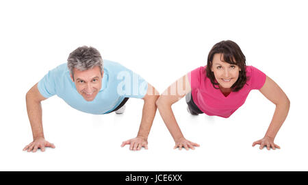 Aktive älteres paar Liegestütze machen. Isoliert auf weiss Stockfoto