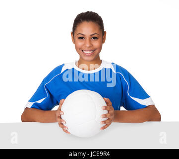 Fröhliches junges Mädchen mit Volleyball und Plakat. Isolated On White Stockfoto