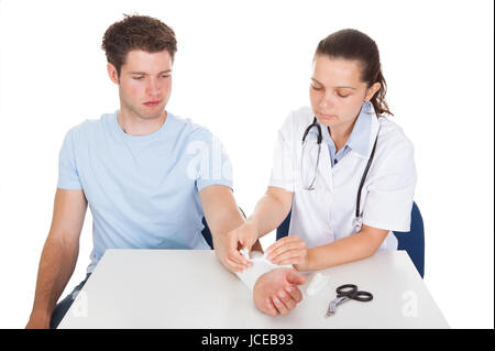 Foto von Frau Doktor Bandagierung des Patienten Handgelenk Stockfoto