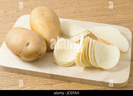Snack Food, Kartoffelknolle mit Kartoffelchips oder knackig auf Holzbrett. Stockfoto