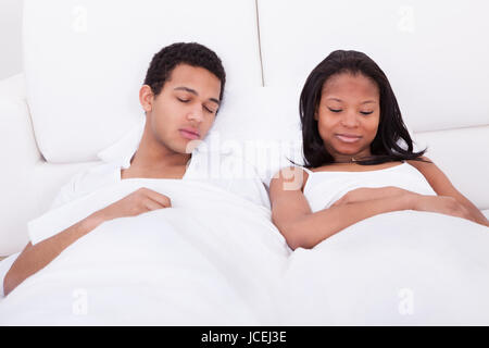 Porträt des jungen Paares auf Bett schlafen Stockfoto