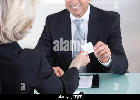 Glücklich Reife Geschäftsleute, die Austausch von Visitenkarte im Büro Stockfoto