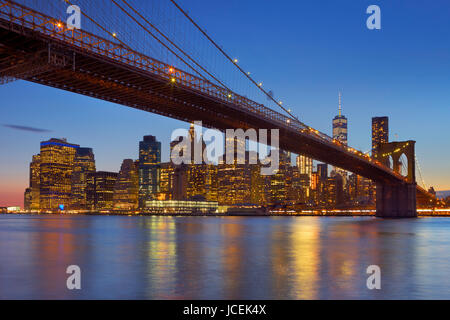 Brooklyn Bridge mit der New Yorker Skyline im Hintergrund, in der Dämmerung fotografiert. Stockfoto