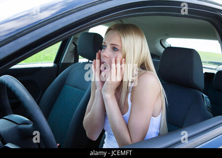 Junge Blonde Frau sitzen im Auto und schreien Stockfoto