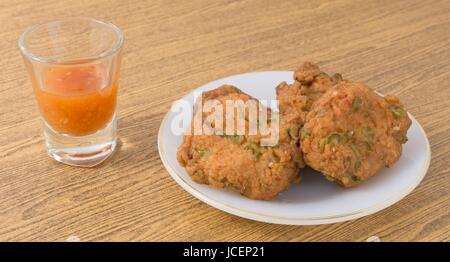 Snack und Dessert, Thai traditionelle gebratener Fisch Kuchen mit süßen würzigen Soße serviert. Stockfoto