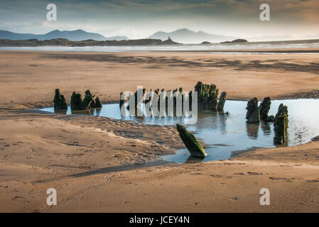 Wrack der Brig Athena auf Penrhos Strand, unterstützt von Llanddwyn Island und der Halbinsel Llyn, Anglesey, North Wales, UK Stockfoto