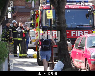 London, UK. 15. Juni 2017. Am Tag nach Grenfell Turm Feuer: Laien die Blumen, an die Tafel schreiben und bringen etwas zu essen und Kleidung Latimer Kirche und Gemeinde, während die Feuerwehr nach und nach das Gebäude, London, UK Credit untersucht: Nastja M/Alamy Live News Stockfoto