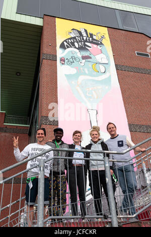 Hamburg, Deutschland. 16. Juni 2017. CEO der Millerntor Gallery Michael Fritz steht gemeinsam mit dem Künstler Jobray aus Uganda, Kurator der Millerntor Gallery Anna Lafrentz, Künstlerin Anne Regier und Club-Präsident des St. Pauli Oke Goettlich vor der Fassade, die Künstlerin Anne Regier in Hamburg, Deutschland, 16. Juni 2017 entworfen wurde. An der internationalen Kunst Musik und Kultur Festival Millerntor Gallery X7 für das siebte Mal rund 100 anwesenden Künstler ihre Werke vom 29. Juni bis 2. Juli im Stadion des FC St. Pauli. Foto: Sina Schuldt / / Dpa/Alamy Live News Stockfoto