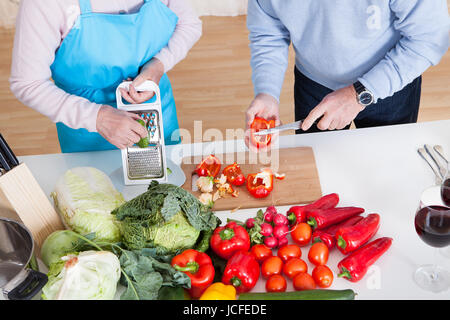 Gerne älteres paar Schneiden von Gemüse In der Küche Stockfoto