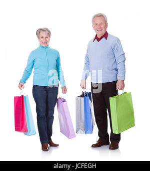 Portrait Of Happy Senior Couple Holding Shopping Bags Stockfoto