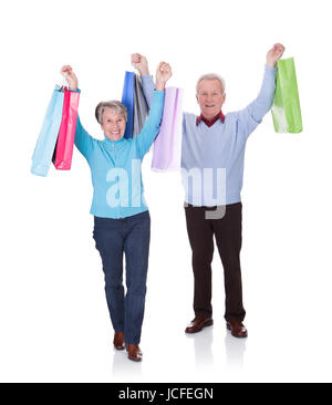 Portrait Of Happy Senior Couple Holding Shopping Bags Stockfoto