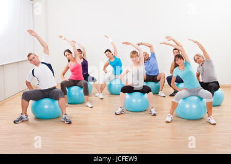 Große Gruppe von verschiedenen Menschen in einer Pilates-Klasse-Turnen in der Turnhalle üben Balance und Kontrolle Stockfoto