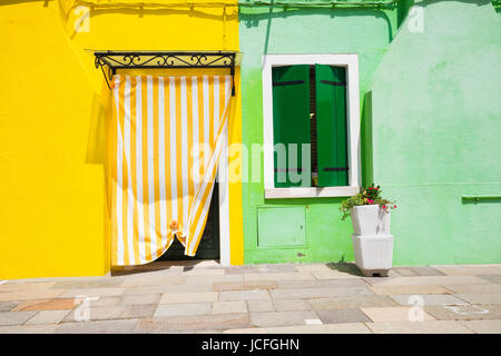 Kleiner, gemütlicher Innenhof mit bunten Häuschen / Burano, Venedig / der kleine Hof mit hellen Wänden von Häusern Stockfoto