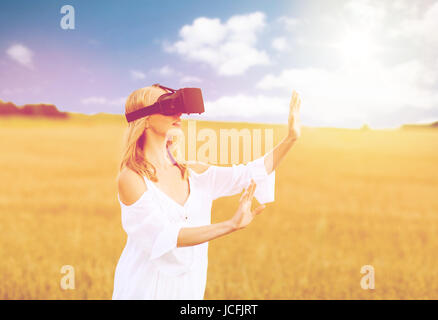 Frau in virtual-Reality-Kopfhörer auf Getreide-Feld Stockfoto