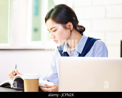 junge asiatische Geschäftsfrau arbeiten Notizen im Büro. Stockfoto