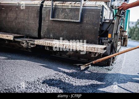 Männliche Arbeitnehmer operativen Asphalt Fertiger Maschinen auf der Baustelle von Straßen und Reparatur arbeiten Stockfoto