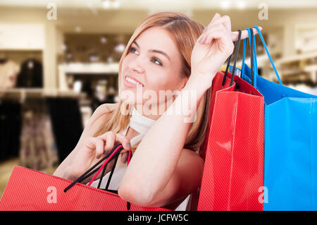 Schönes Porträt der Frau beim Shoppen mit farbigen Geschenktüten in der mall Stockfoto