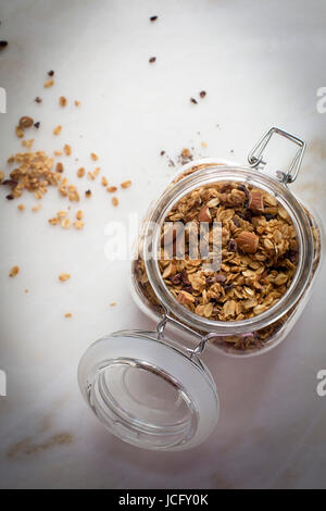 Peanut Butter Müsli in einem Glas auf einem Marmortisch in Draufsicht Stockfoto