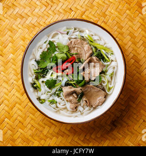 Pho Bo-vietnamesische Suppe mit Rindfleisch mit Bambus Tablett Hintergrund Nahaufnahme Stockfoto