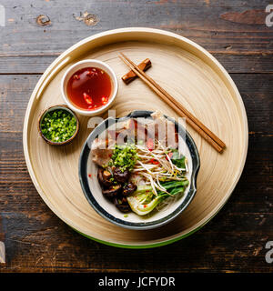Reisnudeln mit gekochtem Schweinefleisch, Weizenkeime und Shiitake-Pilzen auf Holz Hintergrund Stockfoto