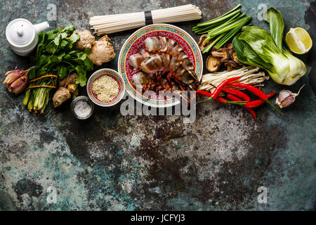 Zutaten für asiatische Kochen mit Tiger Garnelen, Udon-Nudeln, Champignons, grünen Gemüse, Gewürze auf Metall Hintergrund kopieren Raum Stockfoto