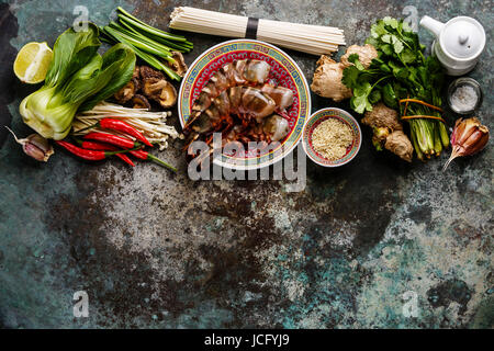 Zutaten für asiatische Kochen mit Tiger Garnelen, Udon-Nudeln, Champignons, grünen Gemüse, Gewürze auf Metall Hintergrund kopieren Raum Stockfoto