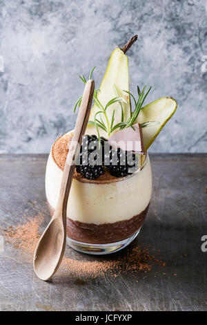 Dessert Frühstück geschichteten Chia-Samen, Schoko-Pudding, Reis Brei aus Glas dekoriert mit frischen Brombeeren, in Scheiben geschnitten Birne, Kakaopulver. Stehen mit Stockfoto