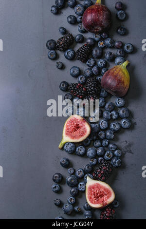 Vielzahl von frischen Beeren Heidelbeeren, Kratzbeere und Feigen in dunklem Metall. Ansicht von oben mit dem Raum. Stockfoto