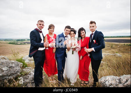 Hochzeitspaar und Braidsmaids mit Trauzeugen Champagner trinken, in einer malerischen Landschaft. Stockfoto