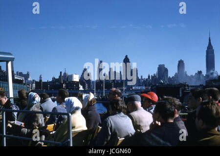 Antike Oktober 1958 Foto, Reisegruppe und die Skyline von New York auf einem Ausflugsboot der Circle Line auf dem Hudson River. Empire State Building auf der rechten Seite. Quelle: ORIGINAL 35mm Transparenz. Stockfoto