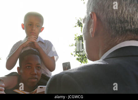 Bürgermeister von London Sadiq Khan wird von Kai Ramos, 7, in der Nähe von Grenfell Turm im Westen von London nach ein Brand 24-geschossiges Hauptgebäude gestern Morgen verschlungen konfrontiert. Stockfoto