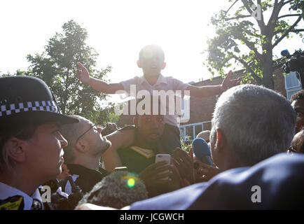 Bürgermeister von London Sadiq Khan wird von Kai Ramos, 7, in der Nähe von Grenfell Turm im Westen von London nach ein Brand 24-geschossiges Hauptgebäude gestern Morgen verschlungen konfrontiert. Stockfoto