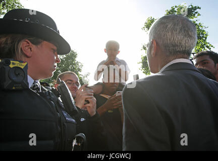 Bürgermeister von London Sadiq Khan wird von Kai Ramos, 7, in der Nähe von Grenfell Turm im Westen von London nach ein Brand 24-geschossiges Hauptgebäude gestern Morgen verschlungen konfrontiert. Stockfoto