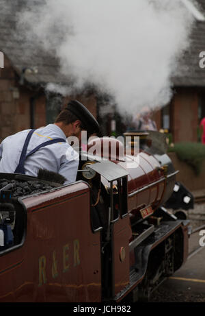Ravenglass und Eskdale Railway Miniatur Dampfmaschine Fluss Mite mit männlichen Lokführer uniformierten mit Kappe Stockfoto
