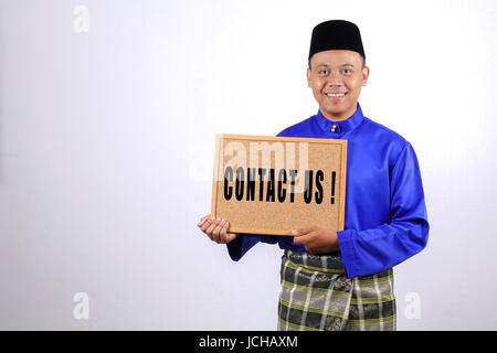 Junger Mann lächelnd mit Tafel für Eid Fitr oder Eid Adha feiern. Stockfoto