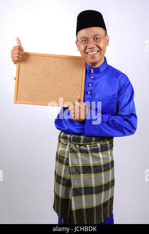 Junger Mann lächelnd mit Tafel für Eid Fitr oder Eid Adha feiern. Stockfoto