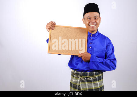 Junger Mann lächelnd mit Tafel für Eid Fitr oder Eid Adha feiern. Stockfoto