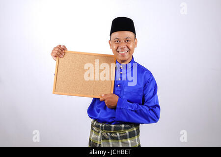 Junger Mann lächelnd mit Tafel für Eid Fitr oder Eid Adha feiern. Stockfoto