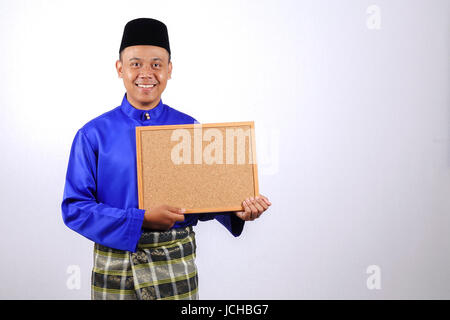 Junger Mann lächelnd mit Tafel für Eid Fitr oder Eid Adha feiern. Stockfoto