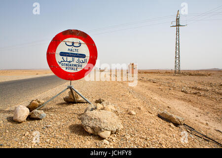 Rot Stop Polizei Zeichen vor einem blauen Himmel auf der Straße nach Ouarzazate in Marokko. Der Text ist geschrieben, ist Arabisch und Französisch, und es sagt "Stop". Stockfoto