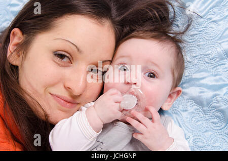 Mutter und Tochter sechs Monate liegen gerne auf der couch Stockfoto