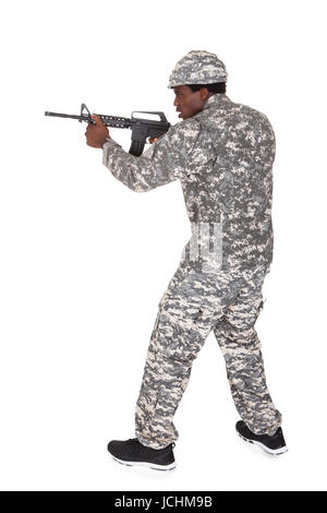 Porträt eines männlichen afrikanischen Soldaten mit dem Ziel mit Gun Isolated Over White Background Stockfoto